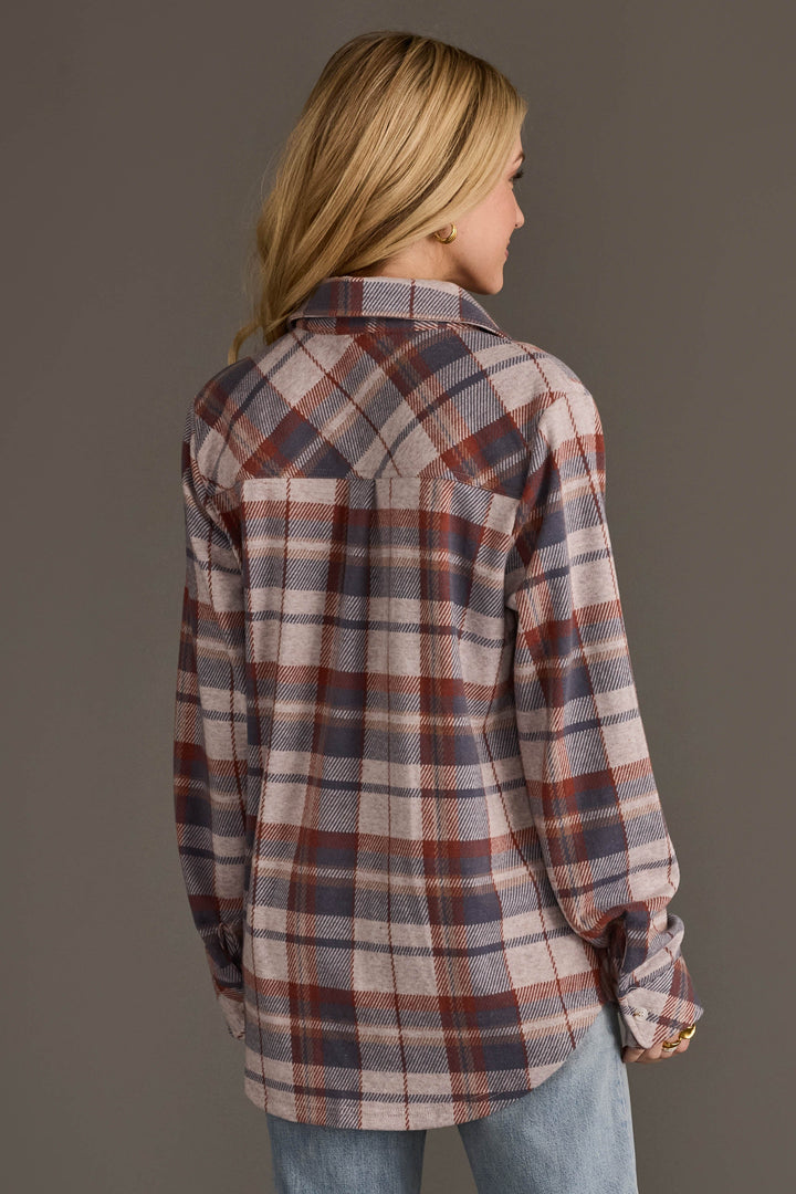 Back view of cream dusty blue and tan plaid flannel button-up shirt on female model