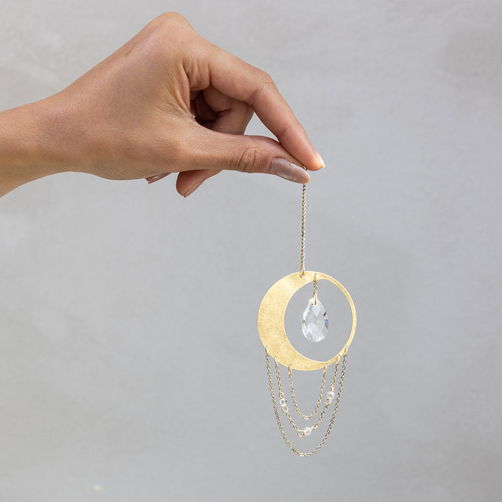 Hand holding Scout Mini Suncatcher with gold crescent moon and crystal drop chains