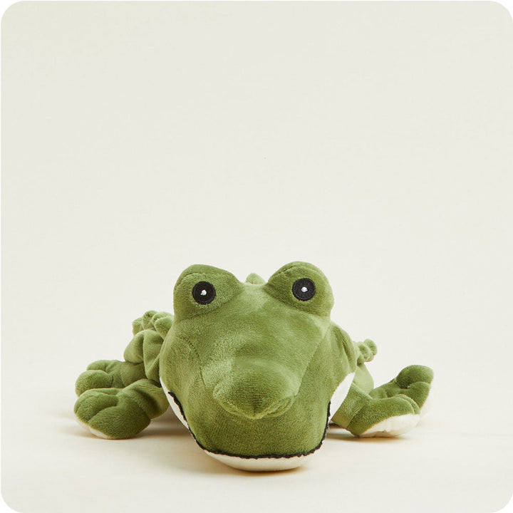 Warmies green alligator plush toy with black eyes against white background