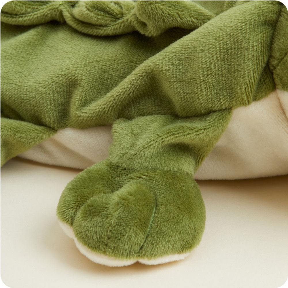 Green plush Warmies stuffed animal with soft fuzzy texture lying on neutral background