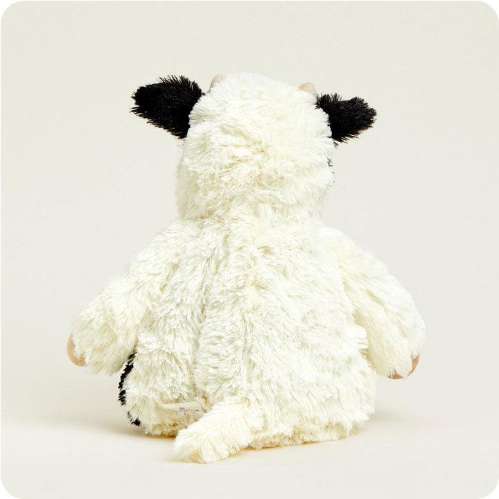Warmies plush cow stuffed animal with cream body and black ears, back view