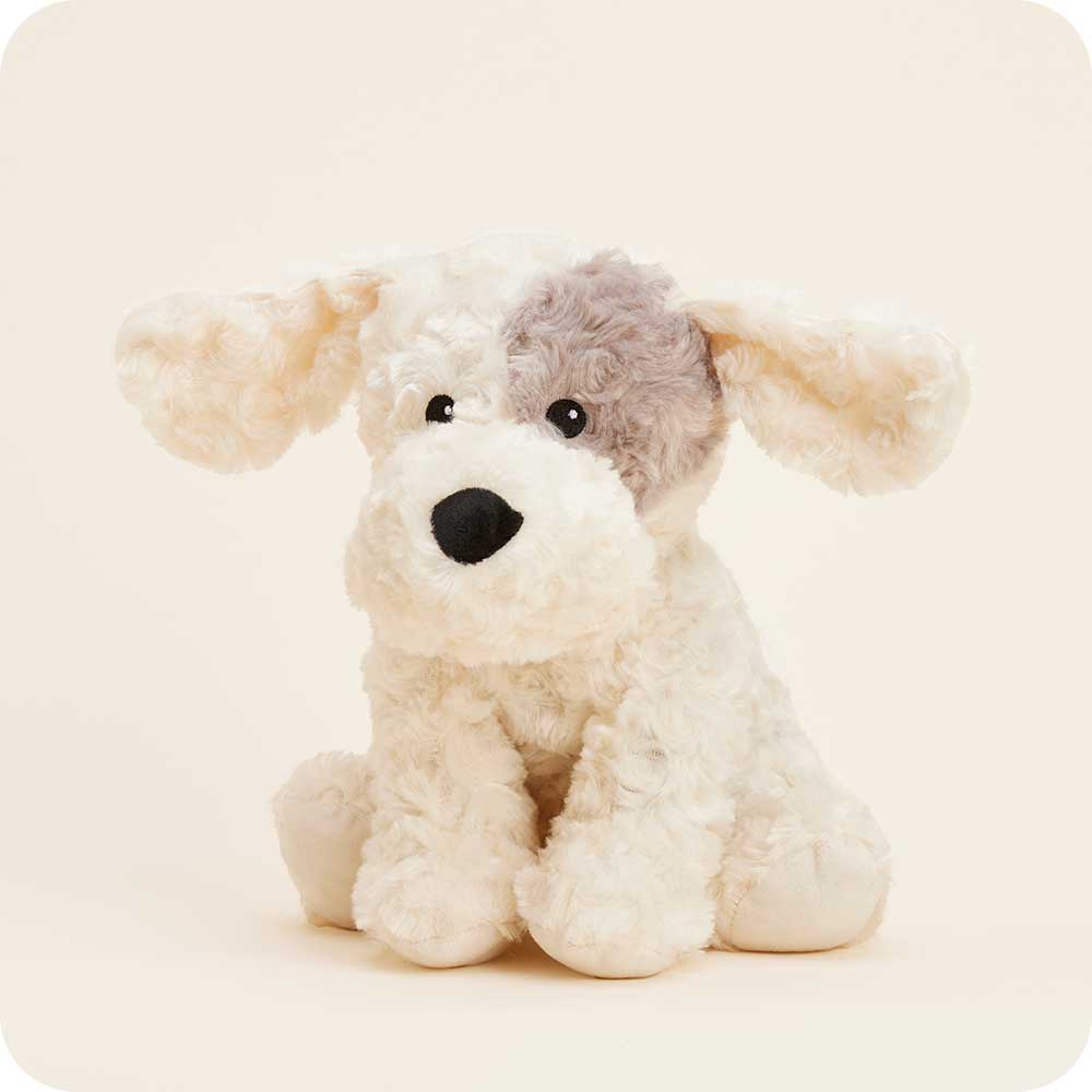 Warmies plush curly dog with cream fur and gray patch over eye