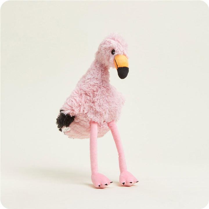 Pink flamingo plush toy with fluffy fur, orange and black beak, long pink legs