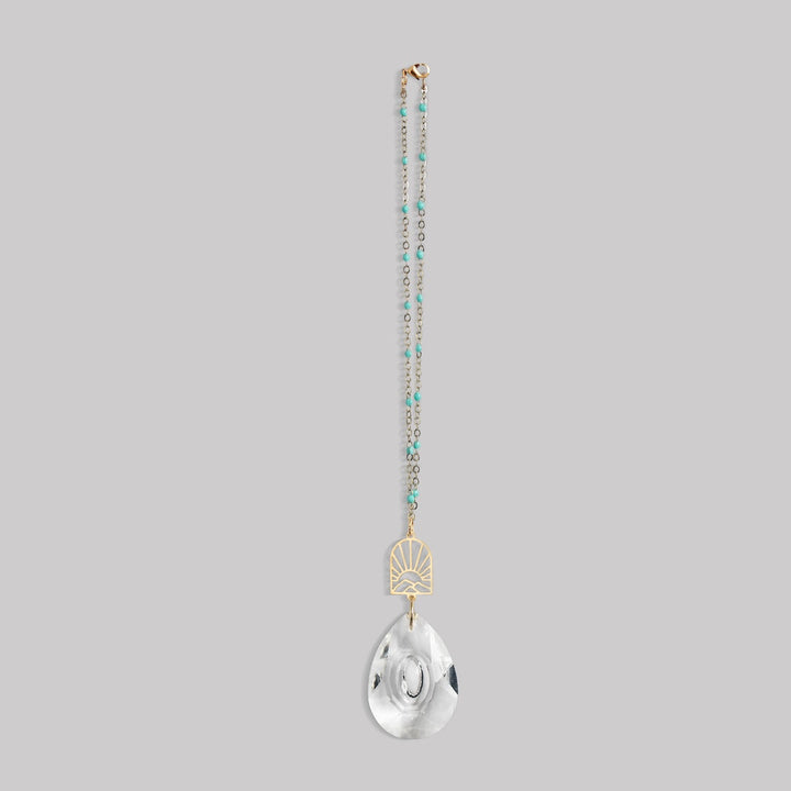 Scout Pocket Suncatcher with turquoise beaded chain, gold sunrise mountain charm, and clear crystal pendant