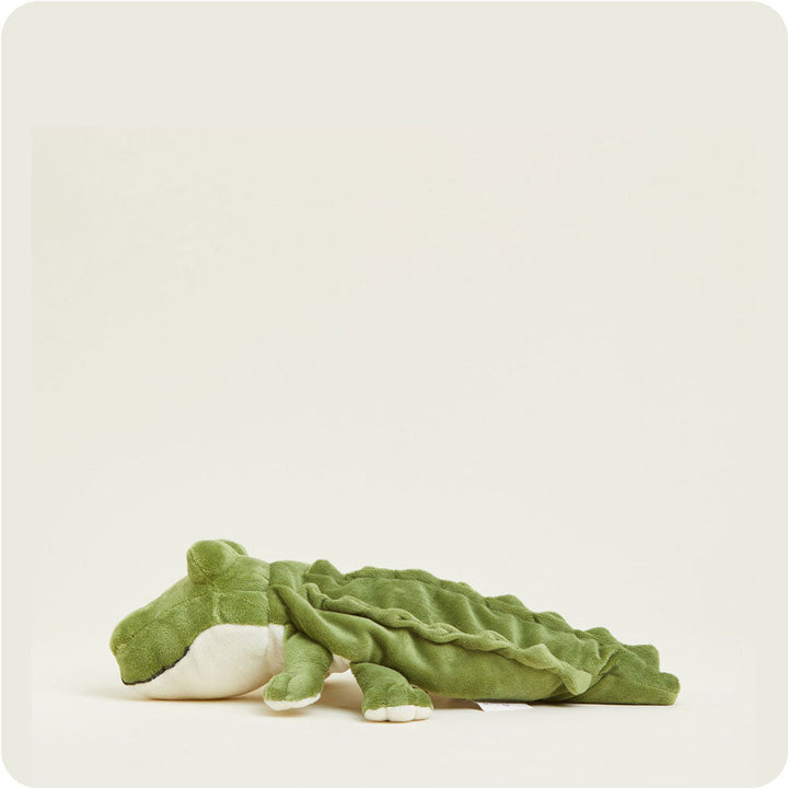 Green alligator-shaped Warmies plush toy with textured fabric and cream belly