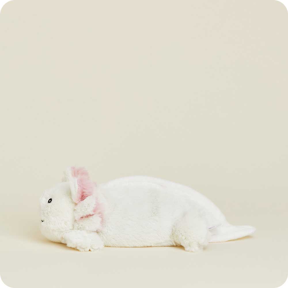 White plush Junior Warmies axolotl with pink inner ears lying on neutral background