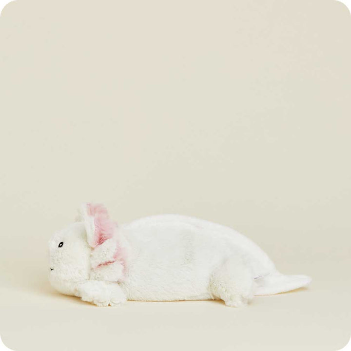 White plush Junior Warmies axolotl with pink inner ears lying on neutral background
