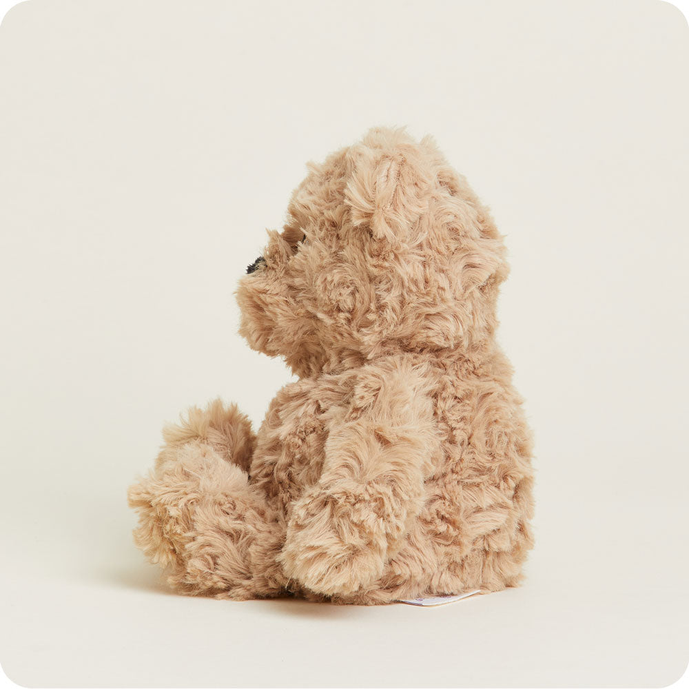 Warmies Junior brown curly plush bear stuffed animal sitting against white background