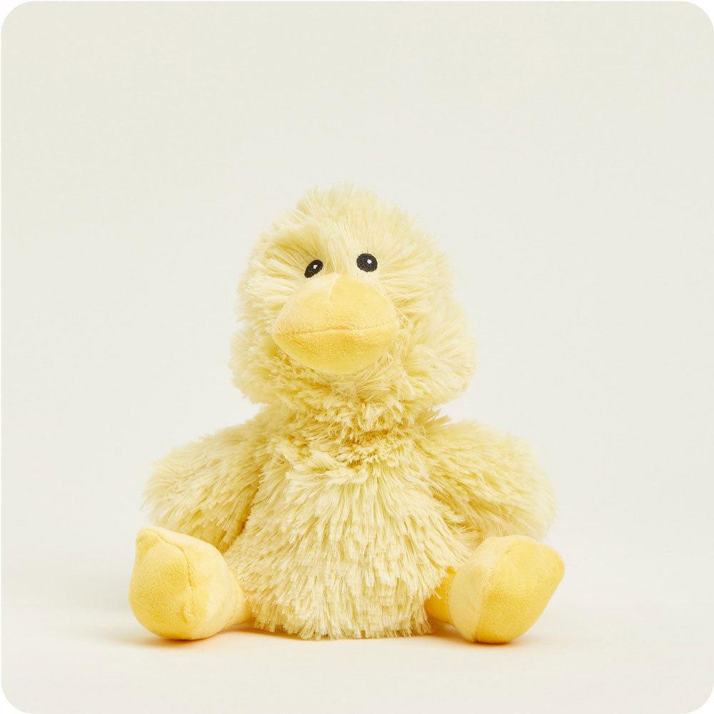 Yellow fuzzy duck plush toy sitting against clean white background