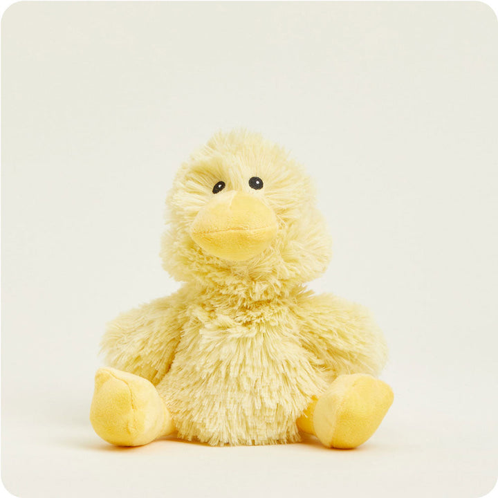 Yellow fuzzy duck plush toy sitting against clean white background