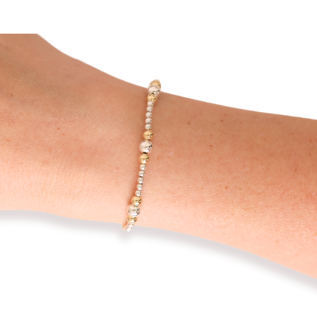 Dainty Sutton beaded bracelet in silver and gold worn on a wrist