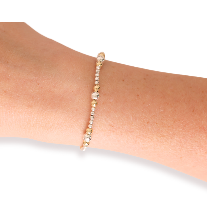 Dainty Sutton beaded bracelet in silver and gold worn on a wrist