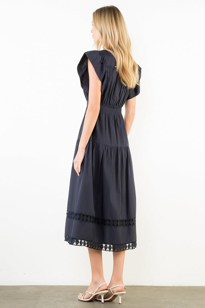 Navy blue tiered midi dress with ruffled sleeves and geometric lace trim detail