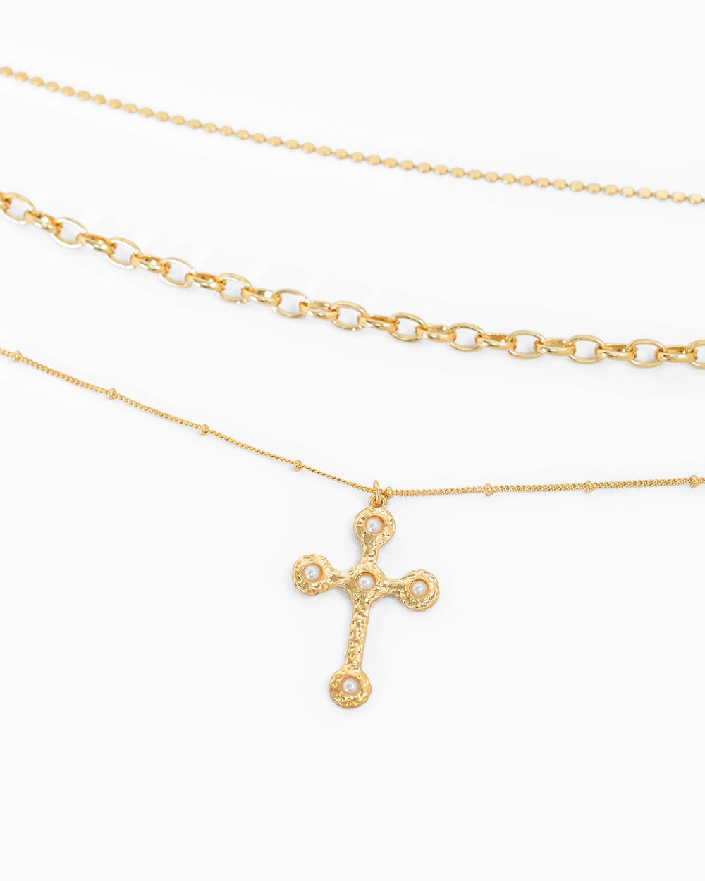 Three layered gold necklaces with hammered cross pendant featuring four pearl accents