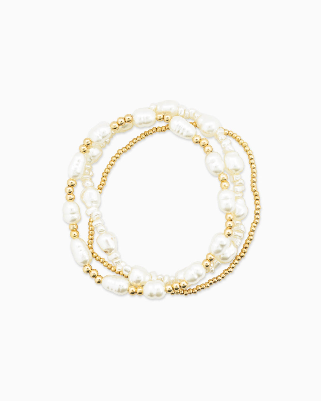 Set of three stretch bracelets featuring white freshwater pearls and gold beads