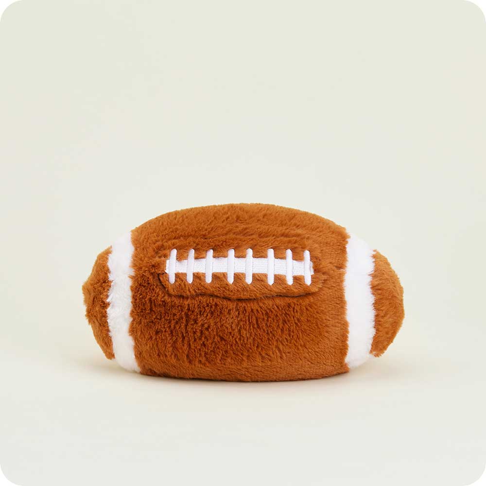 Warmies plush football-shaped heating pad with brown body and white lacing details