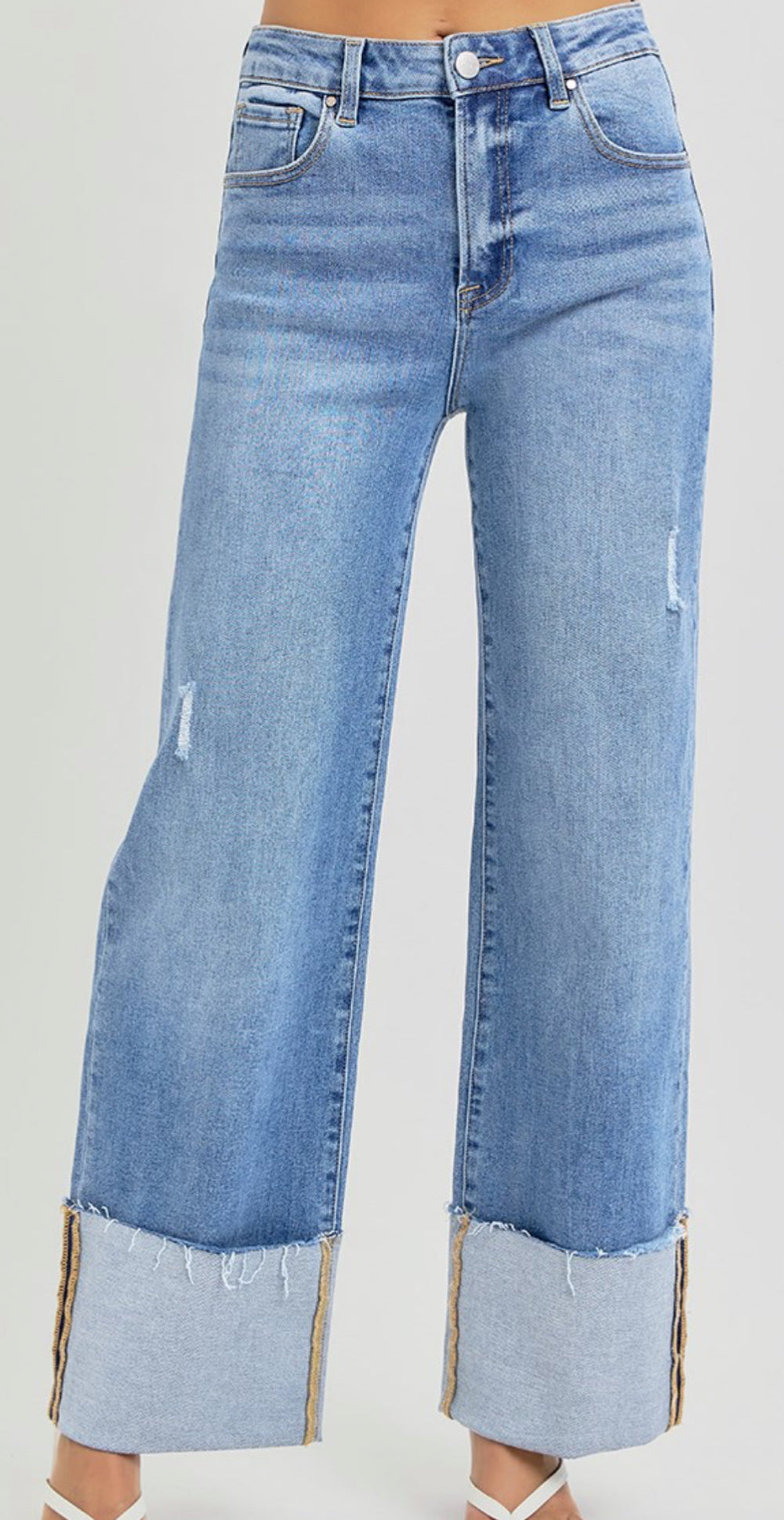 High rise wide leg ankle jeans in medium blue denim with cuffed hem and distressing