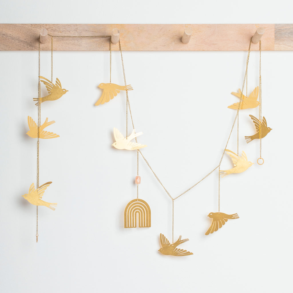 Golden yellow bird garland with hanging chains and decorative rainbow arch centerpiece