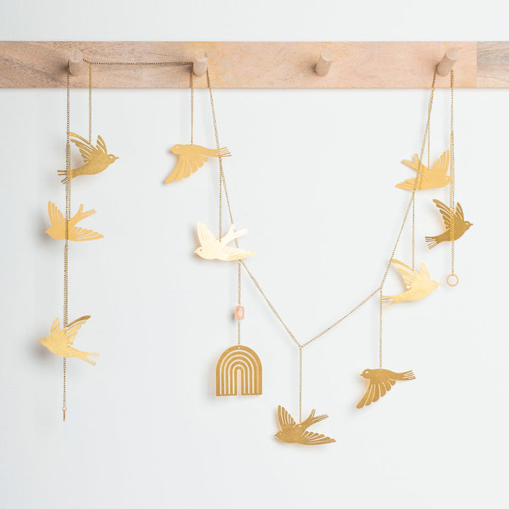 Golden yellow bird garland with hanging chains and decorative rainbow arch centerpiece