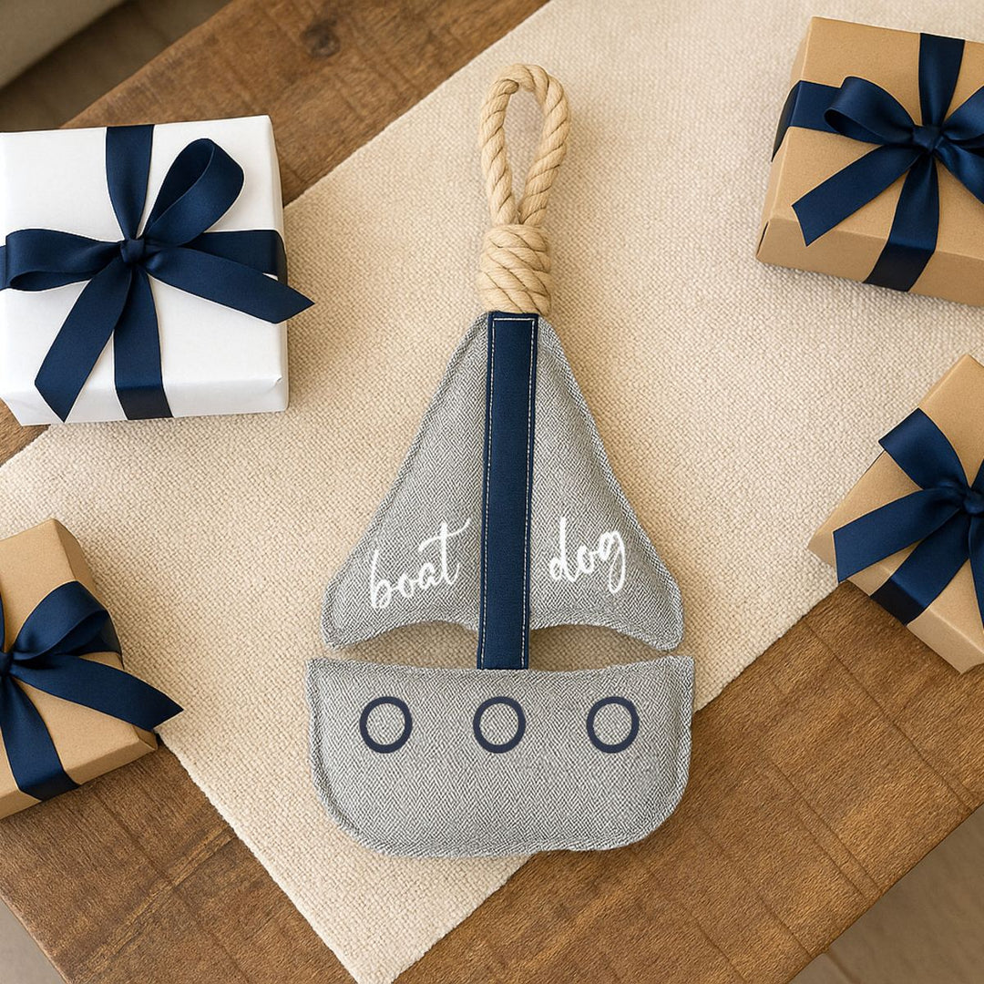 Gray fabric boat-shaped dog toy with rope handle and three portholes