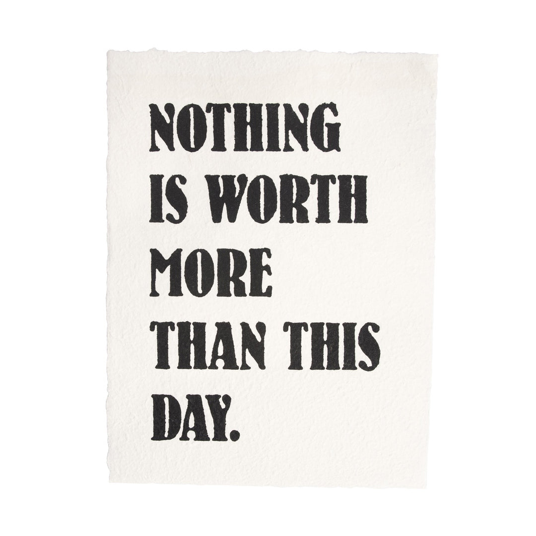 Handmade paper print with bold black text reading 'Nothing Is Worth More Than This Day'