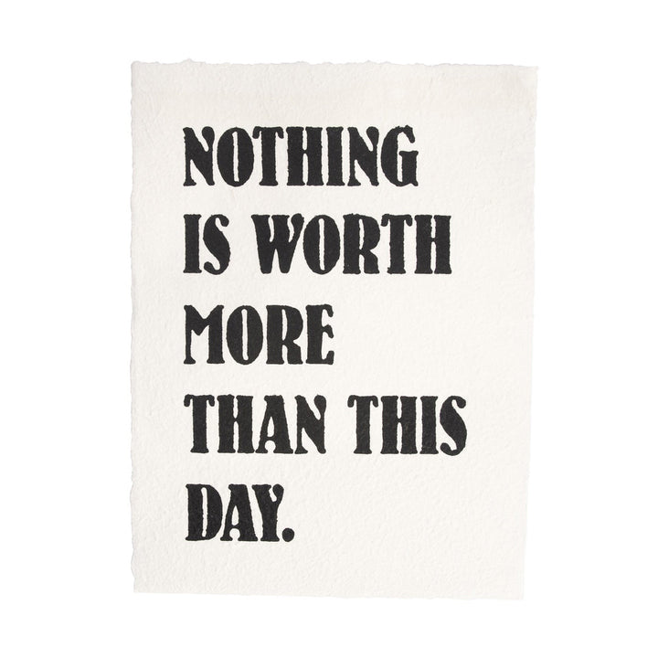 Handmade paper print with bold black text reading 'Nothing Is Worth More Than This Day'