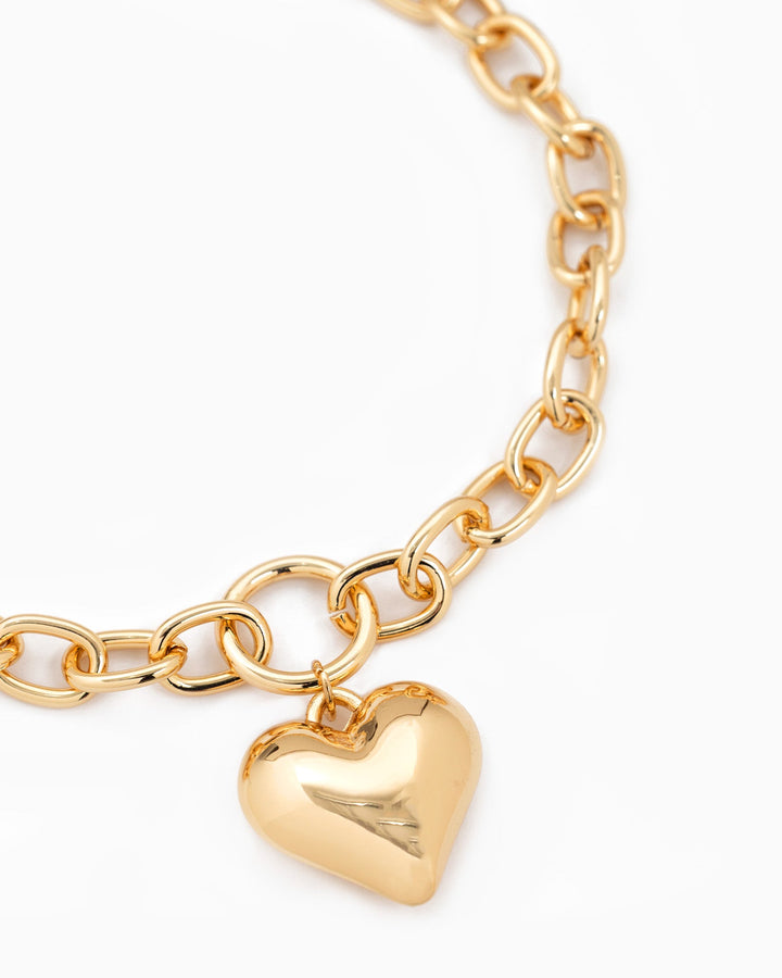 Gold chunky oval chain necklace with a large polished puffy heart charm pendant.