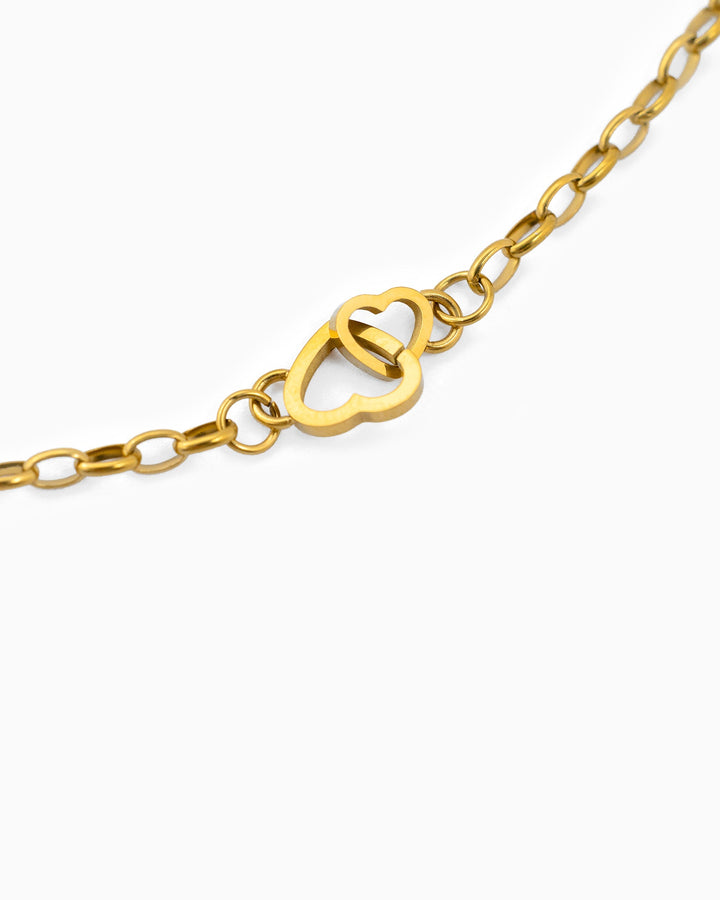 Gold stainless steel chain necklace featuring two interlocked open heart charms as centerpiece.