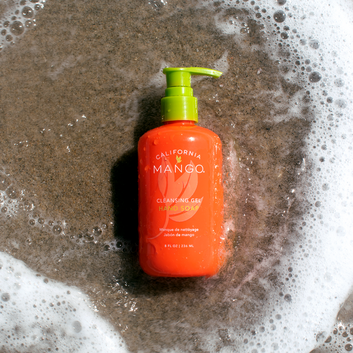 California Mango Cleansing Gel Hand Soap 8oz in orange pump bottle surrounded by soap suds