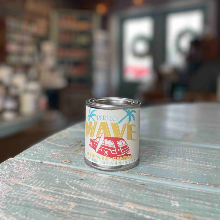 Surfs Up Candle Perfect Wave paint can pint candle with retro surf-themed label on rustic table