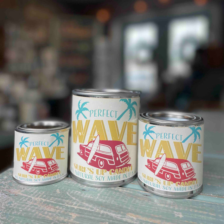 Surfs Up Candle Perfect Wave paint can candles in three sizes on a weathered teal surface