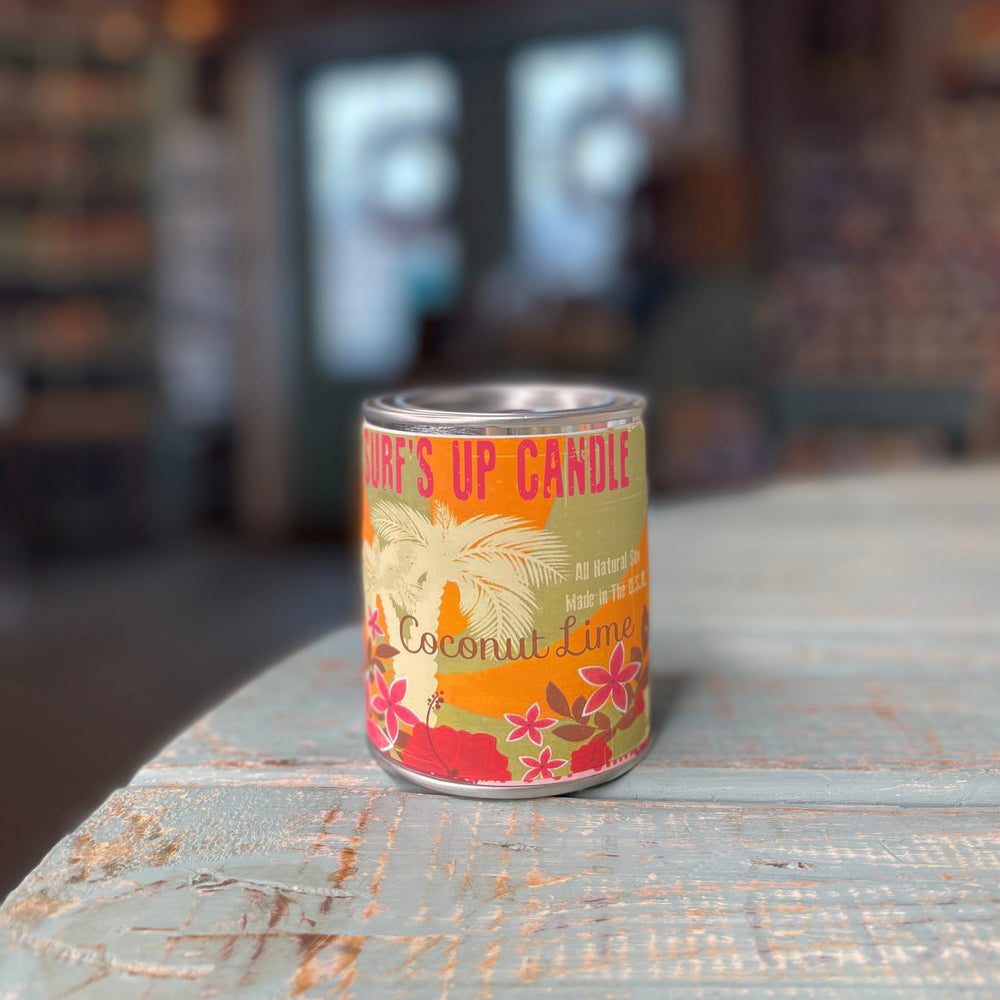 Surf's Up Candle Coconut Lime scented pint paint can with tropical floral label on rustic surface.