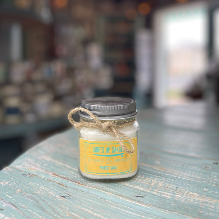 Surf's Up Candle Perfect Wave soy candle in a mason jar with twine bow on rustic teal surface
