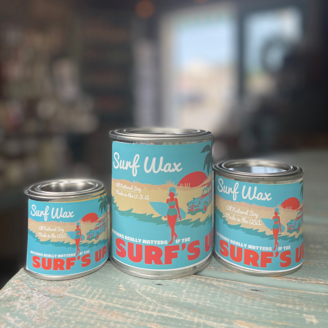 Surf Wax Paint Can Candle in three sizes with retro beach-themed teal label on rustic surface.