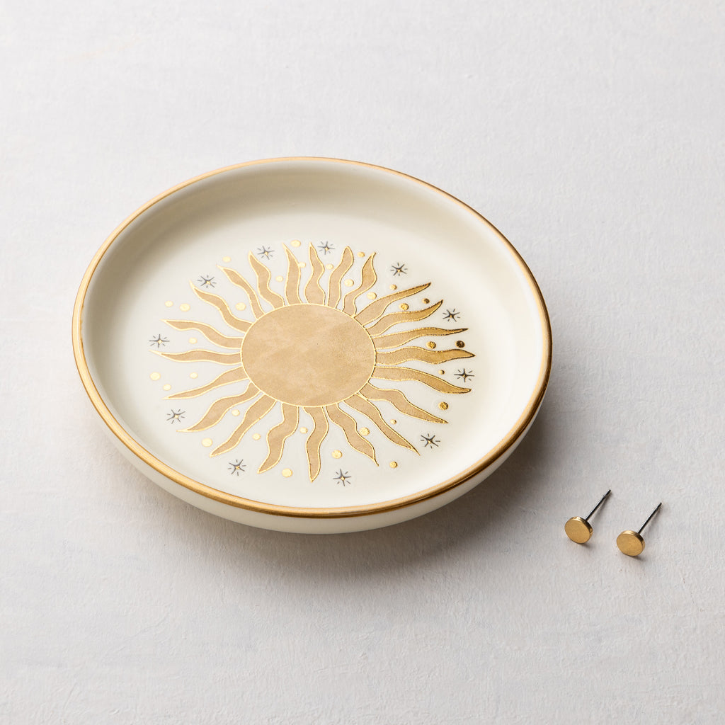 Scout ceramic jewelry dish with golden sun rays design and matching gold stud earrings