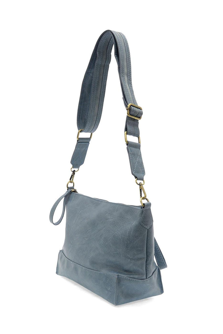 Chambray blue crossbody bag with adjustable strap and seamed design details