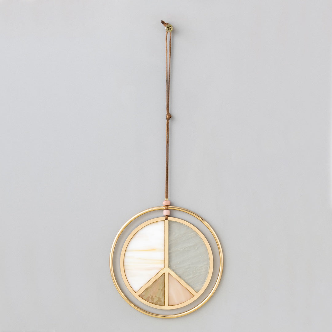 Stained glass peace sign light catcher with gold frame hanging from cord