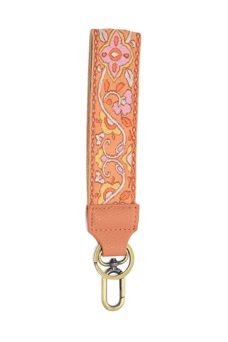 Orange floral embroidered wristlet keychain with tan leather tab and gold clasp