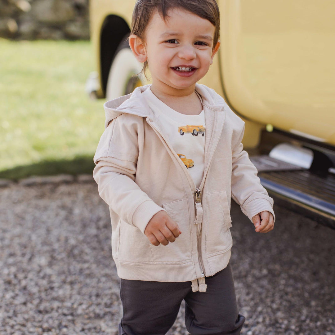 Toddler wearing Burt's Bees Baby 3-piece truck set with hoodie and gray pants
