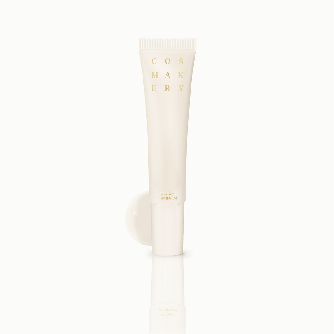 Cosmakery Glowy Lip Balm in vanilla cream colored tube on clean background
