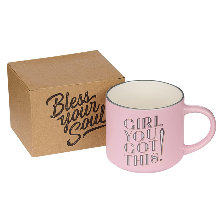 Pink ceramic mug with 'Girl You Got This' text beside brown packaging box