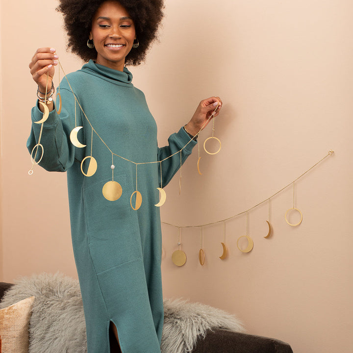 Gold metallic garland with moon phases and circles hanging decoratively