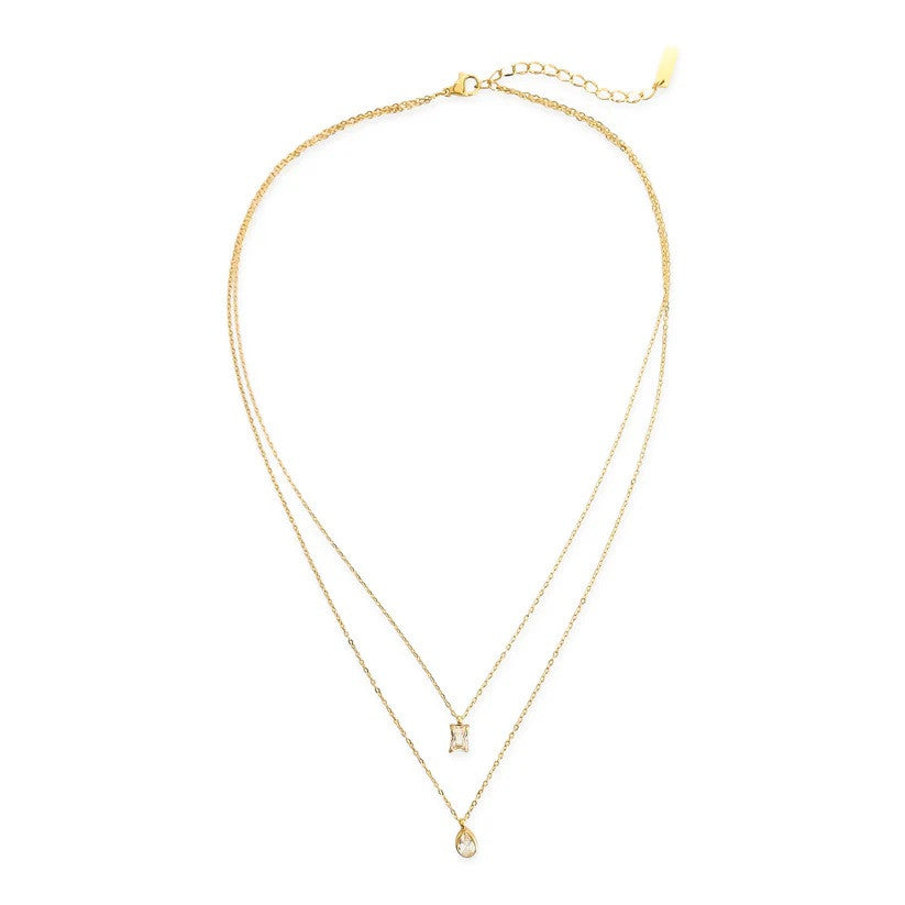 Gold layered necklace with rectangular charm and circular pendant on white background