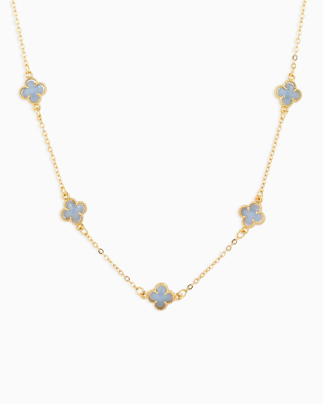Gold station necklace featuring five pastel blue four-leaf clover charms evenly spaced