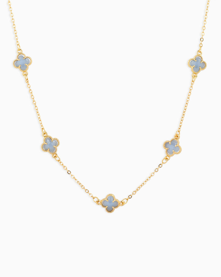 Gold station necklace featuring five pastel blue four-leaf clover charms evenly spaced