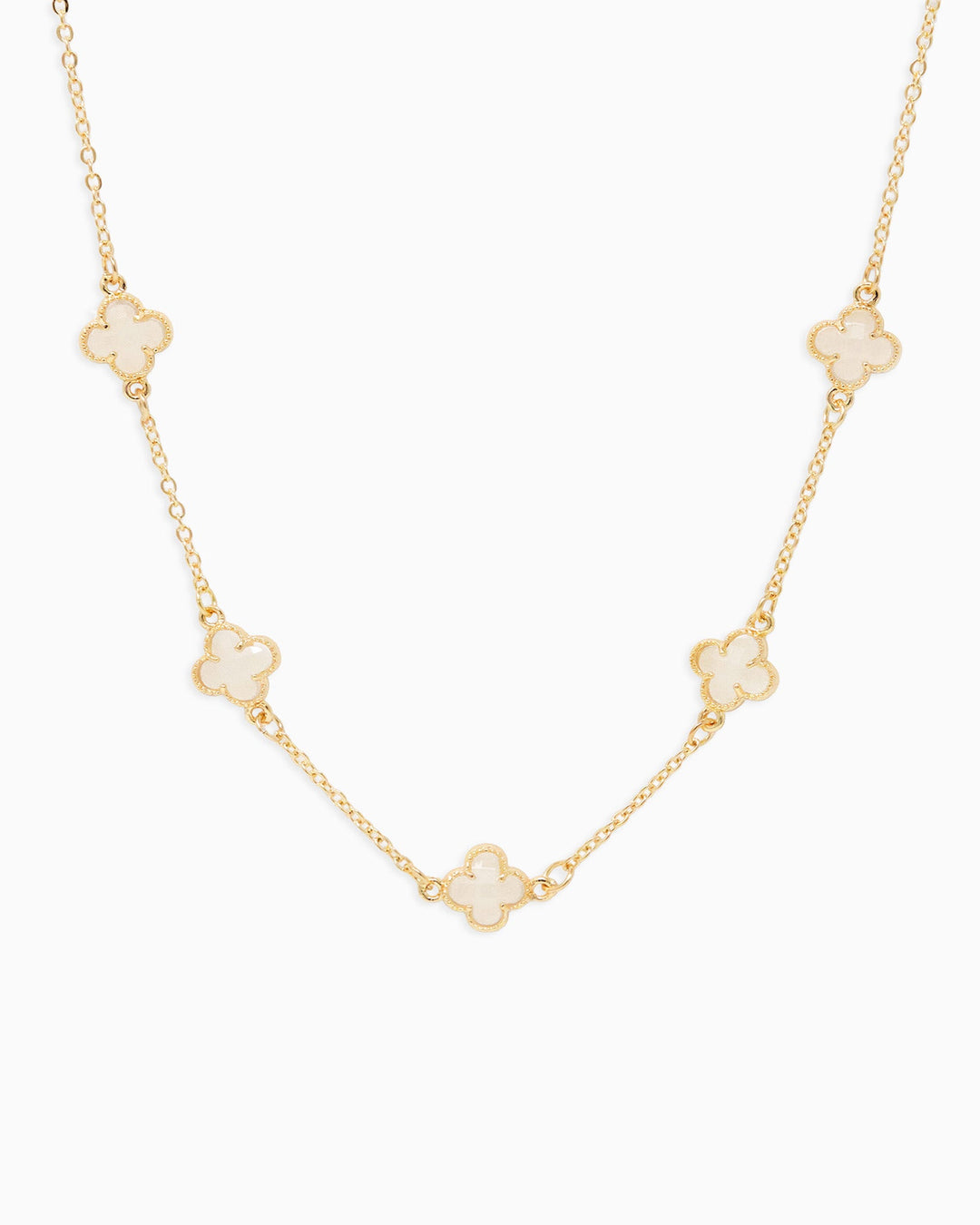 Gold chain station necklace featuring five white mother of pearl four-leaf clover pendants
