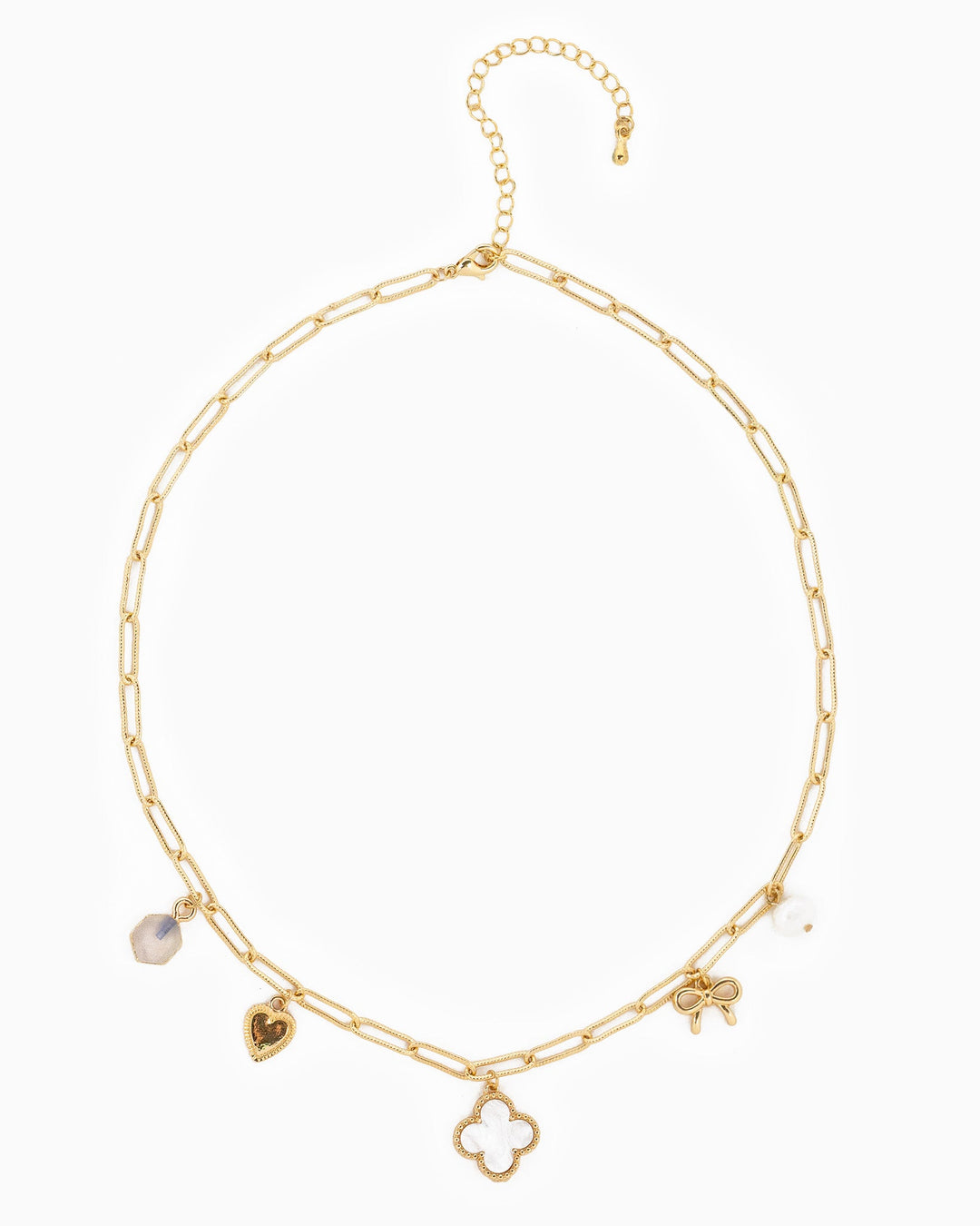 Gold paperclip chain necklace with clover, heart, bow, and crystal charms on white background.
