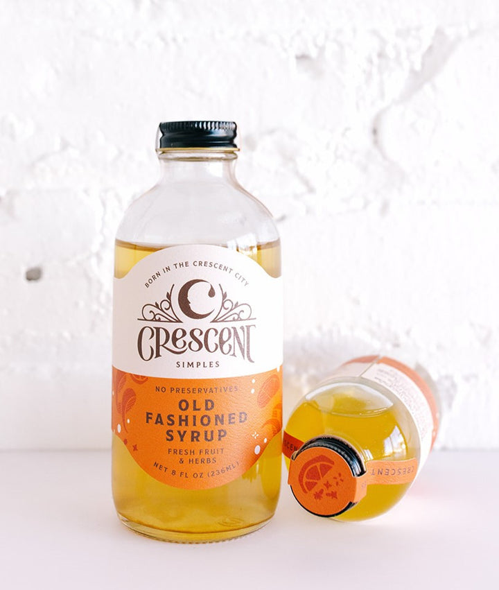 Crescent Simples Old Fashioned Syrup bottle with golden amber liquid and glass mug