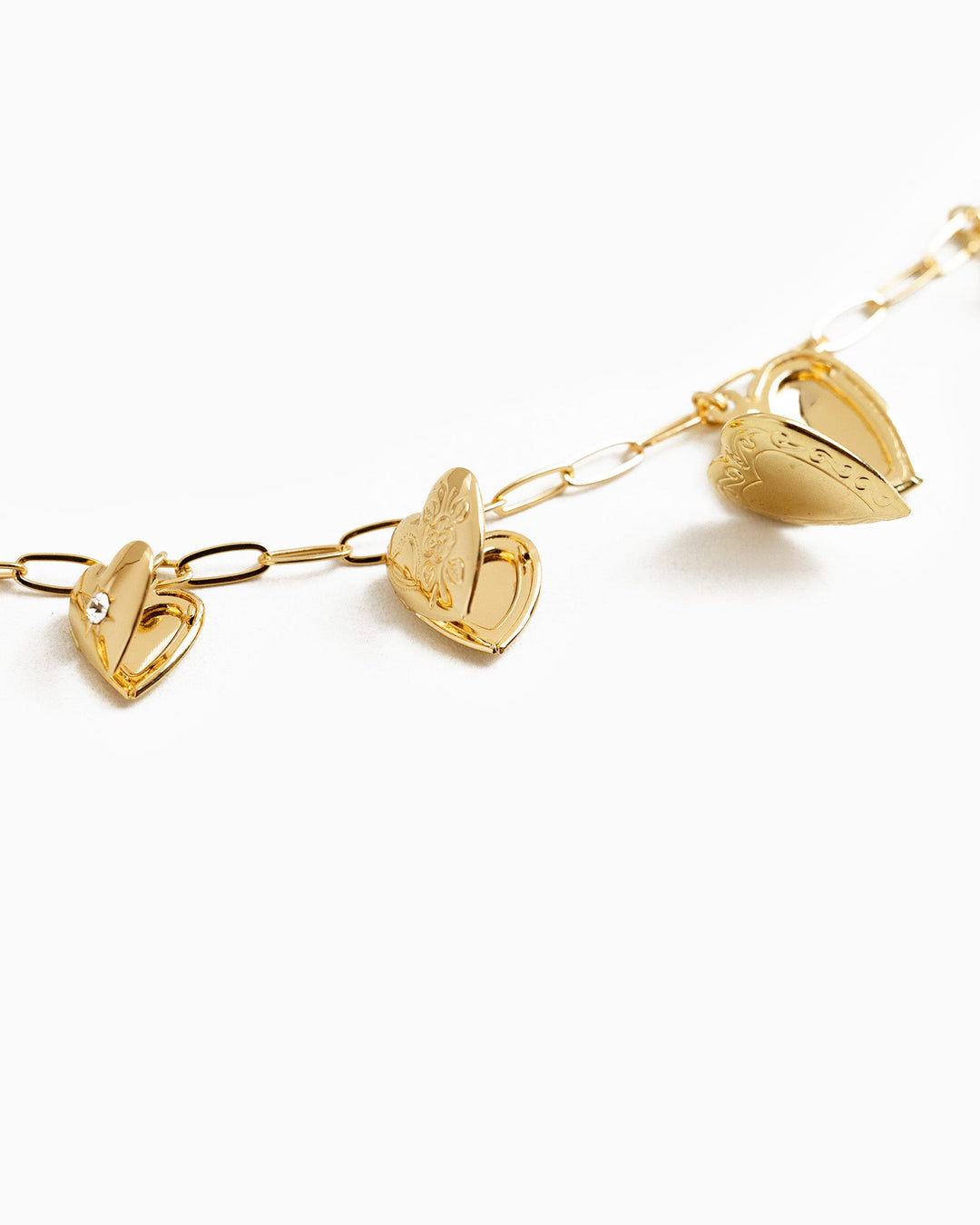 Sessori Seven Heart Locket Charm Necklace featuring gold heart-shaped lockets on a paperclip chain.