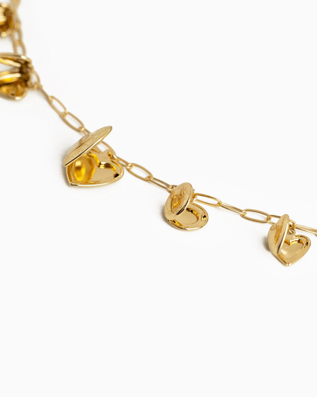 Gold charm necklace featuring multiple open heart locket charms on a delicate chain.